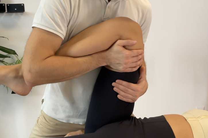 Fizjoterapeuta podczas terapii nogi – FizjoStyl Kraków