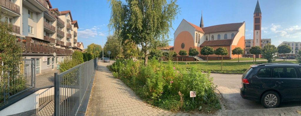 Okolica gabinetu FizjoStyl na Klinach – chodnik wzdłuż budynku i kościół po drugiej stronie ulicy